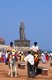 India: Horses for hire on the beach  with the statue of the Tamil poet and saint, Thiruvalluvar in the background, Kanyakumari, Tamil Nadu